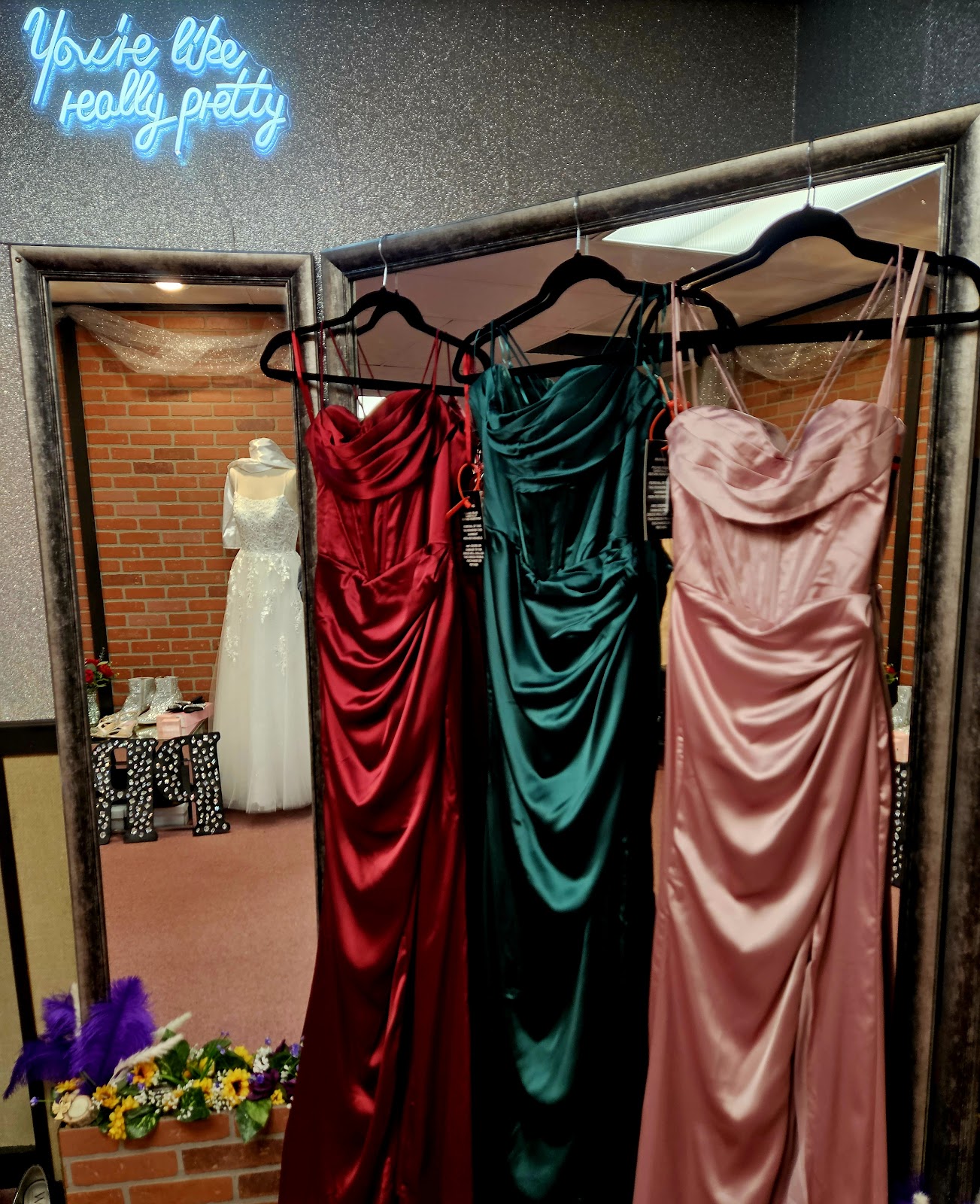 Bridesmaid gowns in burgundy, emerald, and mauve satin